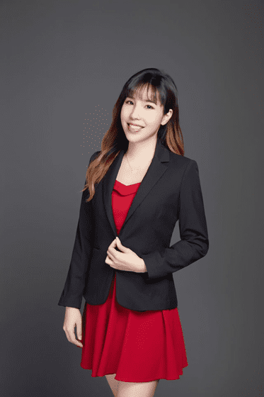 Smiling woman in red dress and blazer.